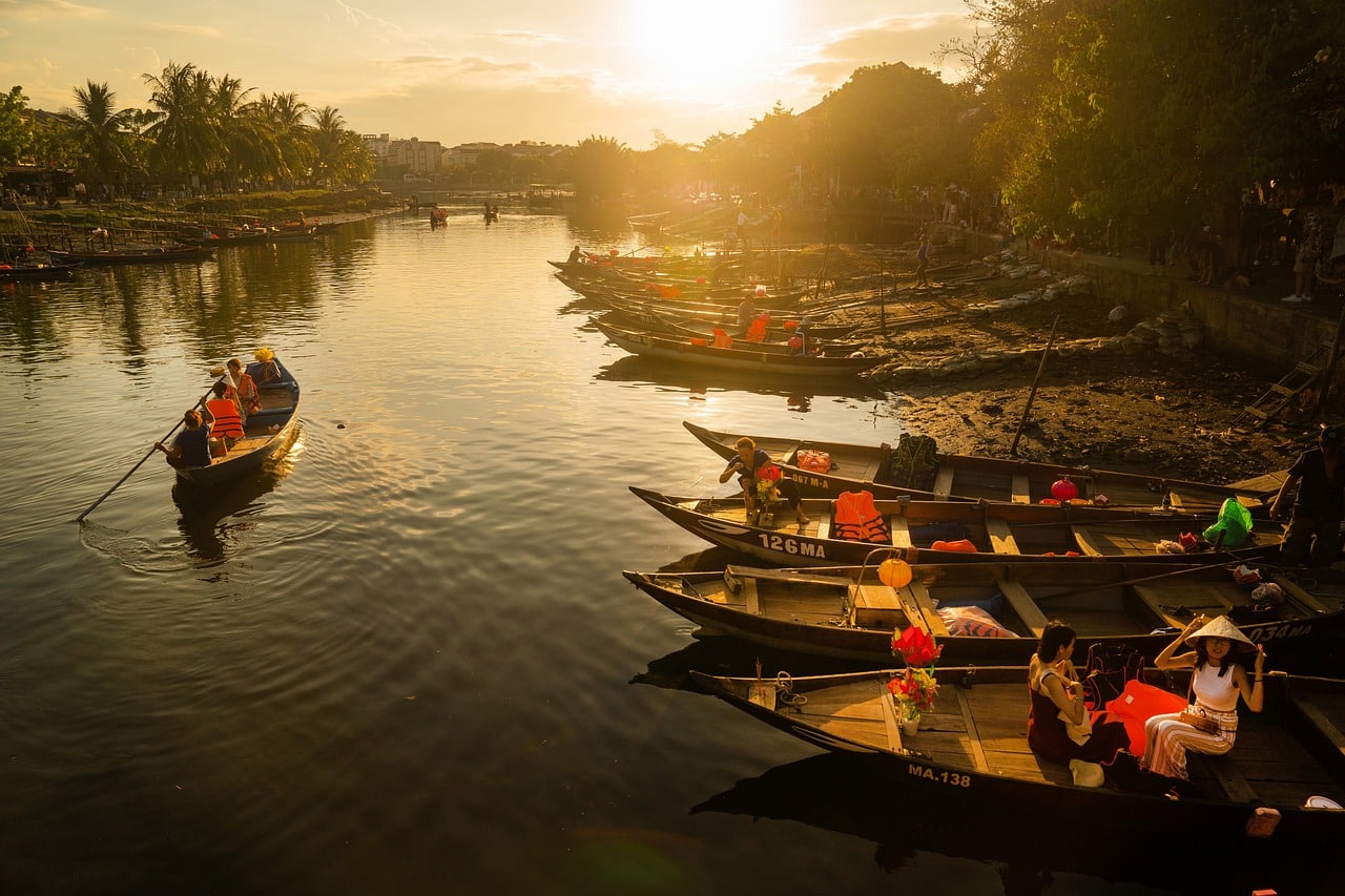 Wooden boats on the Thu Bon river at sunset in Hoi An