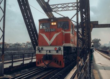A Vietnamese passenger train at a station, representing the Reunification Express route