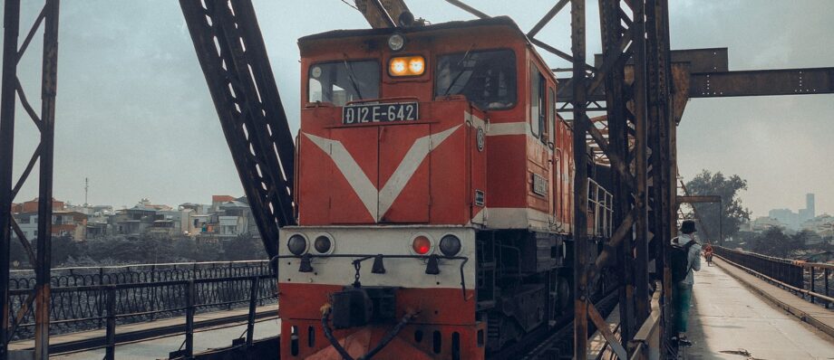 A Vietnamese passenger train at a station, representing the Reunification Express route
