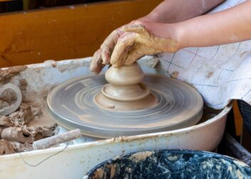 Hands shaping clay on a potters wheel