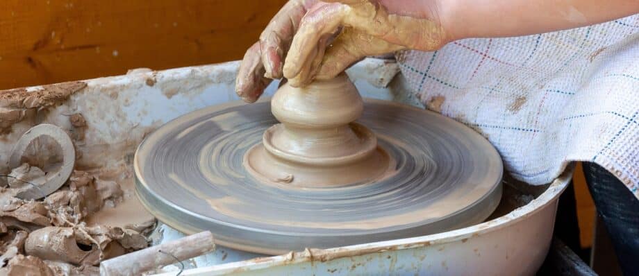 Hands shaping clay on a potters wheel