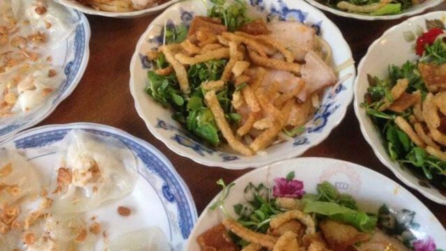 Five bowls of Hoi An Vietnamese noodles with herbs and pork, plus steamed rice rolls topped with fried shallots.