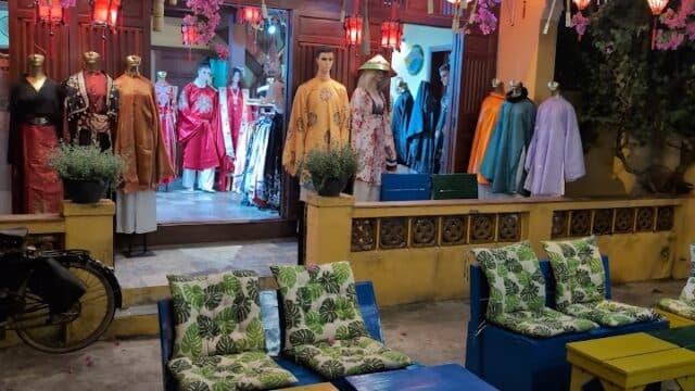 Binano Bar Cafe: Outdoor shop with colorful lanterns, mannequins in traditional clothing, and patterned chairs in front.