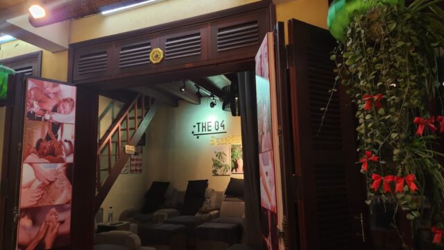 A cozy spa interior with massage chairs, dim lighting, and photos of treatments at the entrance.