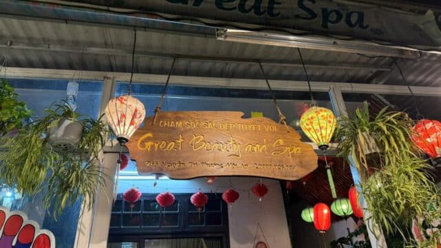 A wooden sign for Great Beauty and Spa hangs above the entrance, decorated with lanterns and plants.