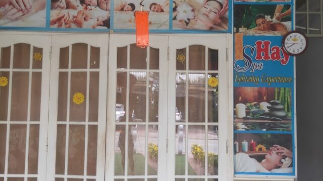White double doors with glass panels, spa posters, and relaxation images above and beside the entrance.