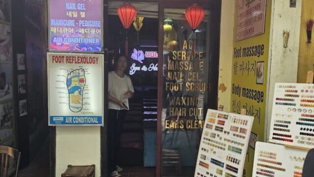 Entrance to a spa with colorful nail polish displays and signs advertising various massage and beauty services.