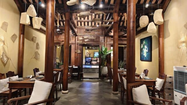 Cozy restaurant with wooden beams, soft lighting, leaf-shaped wall decor, and the inviting aroma of fresh coffee.