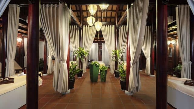 Luxurious Lemongrass Spa interior with curtained massage beds, potted plants, soft lighting, and a serene, natural skincare-inspired atmosphere.
