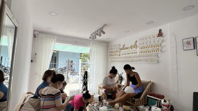Several women relax at Mai Spa & Nail, enjoying manicures in a bright nail salon filled with vibrant polish and modern salon tools.
