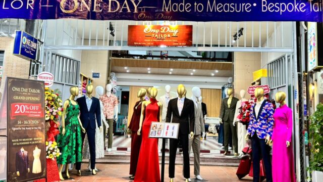 Storefront with mannequins in formal wear; One Day Tailor offers a 20% off grand opening sale.