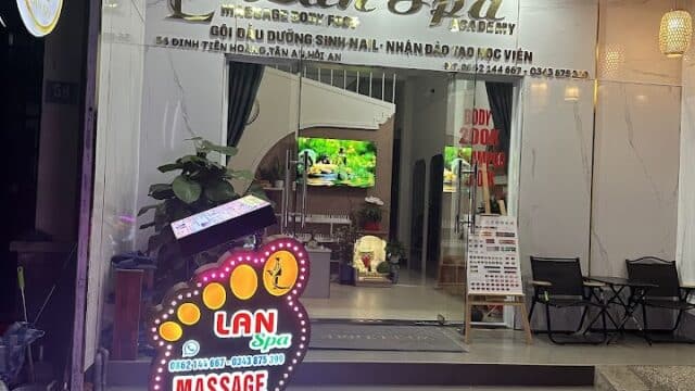 Lan Spa storefront at night with a bright neon sign advertising massage, foot, body, nail, and shampoo services.