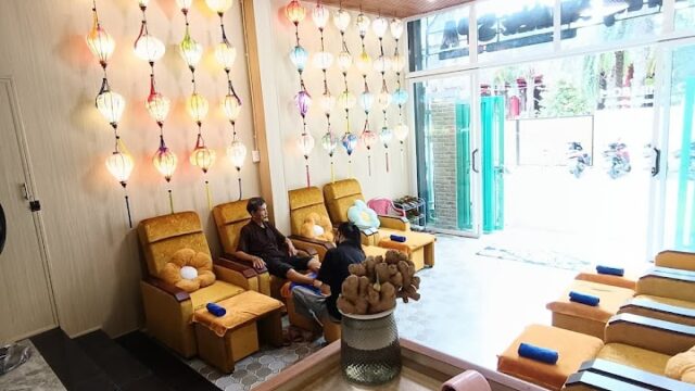 Bright, cozy spa with armchairs, colorful lanterns, and two people seated near the entrance soaking up spring sunshine.