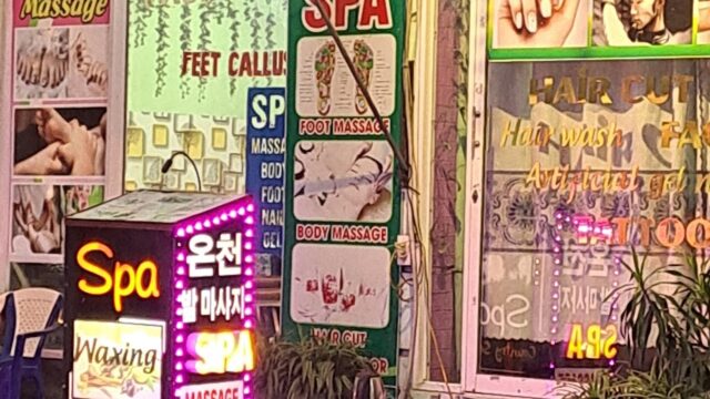 A street view showing brightly lit Thien My Spa and massage signs in English and Korean outside a shop at night.