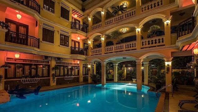 Night view of Thuy Duong 3 Boutique Hotel with balconies and a blue pool, perfect for relaxation at the on-site spa.