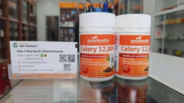 Two bottles of Goodhealth Celery 12,000 sit by an ABC Pharmacy card in a Hoi An store setting.