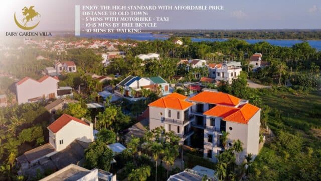 Aerial view of Fairy Garden Villa in Hoi An, surrounded by greenery and houses, with text about its location and transportation options.