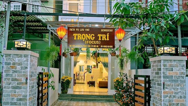 A modern three-story homestay in Hoi An with a welcoming entrance and lanterns, named Trọng Trí (Focus).
