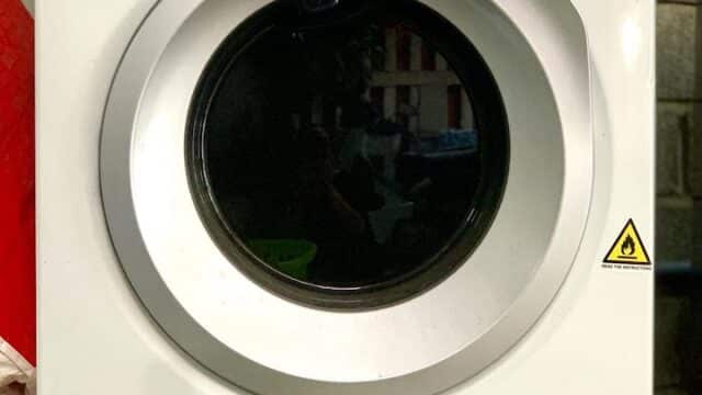 A white Electrolux front-loading washing machine, ideal for Hoi An homes, with a digital control panel and 10-year motor warranty sticker.