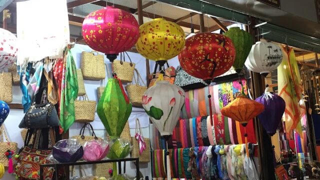 A Vietnamese souvenir shop in Hoi An selling lanterns, scarves, bags, and colorful handmade items.