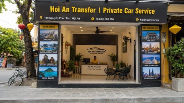 Front view of Hoi An Transfer private car service office in Hoi An, featuring tour posters and an open entrance.