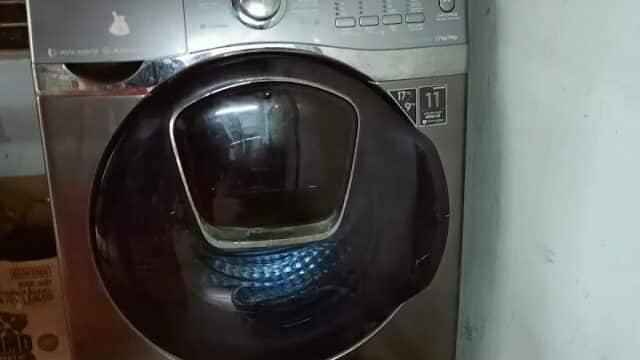 A washing machine with folded clothes on top, a laundry basket filled with clothes in front—like laundry day in Hoi An.