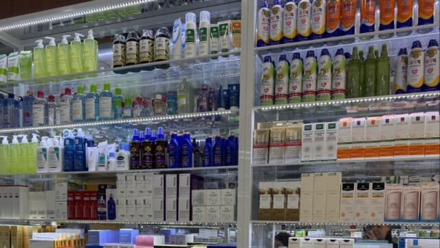 Shelves filled with various skincare and personal care products in a brightly lit Hoi An display case.