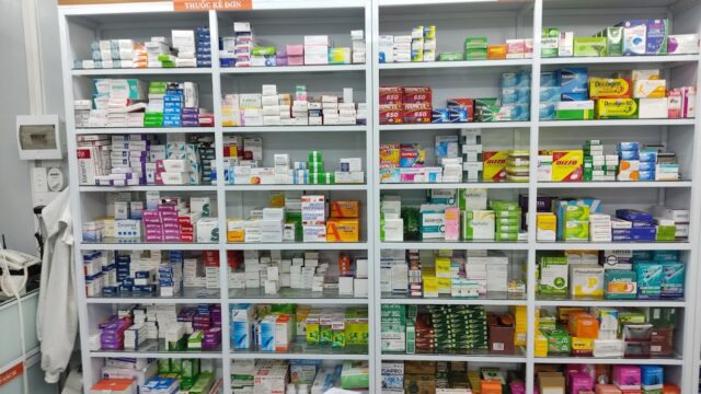 Shelves filled with various medications and health products in a Hoi An pharmacy.