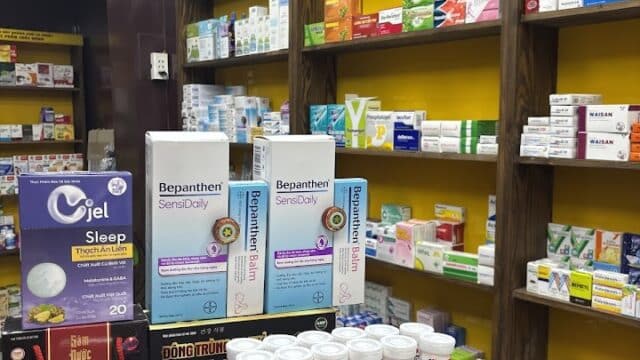 Shelves of medicine and supplements in a Hoi An pharmacy, with various boxes and bottles on display.
