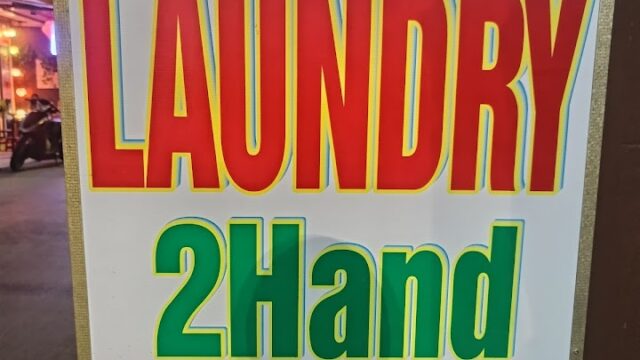 A sign reads: Mrs. HAO LAUNDRY 2Hand, 40 Tran Cao Van Str, Hoi An in colorful, bold letters welcoming you to Hoi An’s charm.