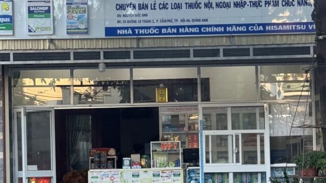 A pharmacy storefront in Hoi An, Vietnam with Salonpas and Hisamitsu signs displayed above and around the entrance.
