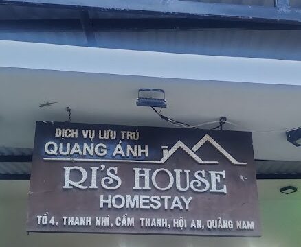 Sign for Rs House Homestay with address details, above a glass door entrance, showcases the cozy interior in beautiful Hoi An, Vietnam.