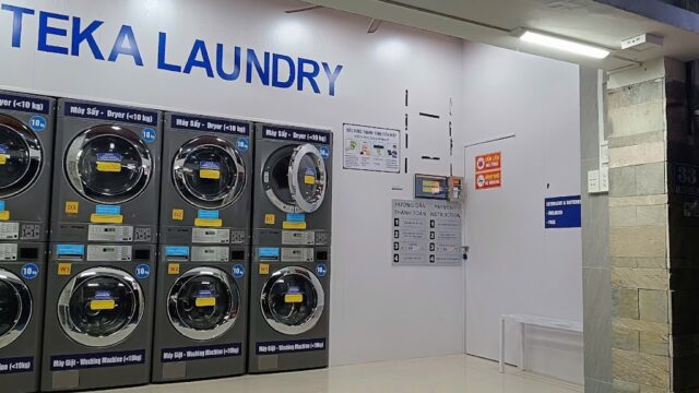 Self-service laundromat in Hoi An with eight front-loading washing and drying machines, all labeled TEKA LAUNDRY.